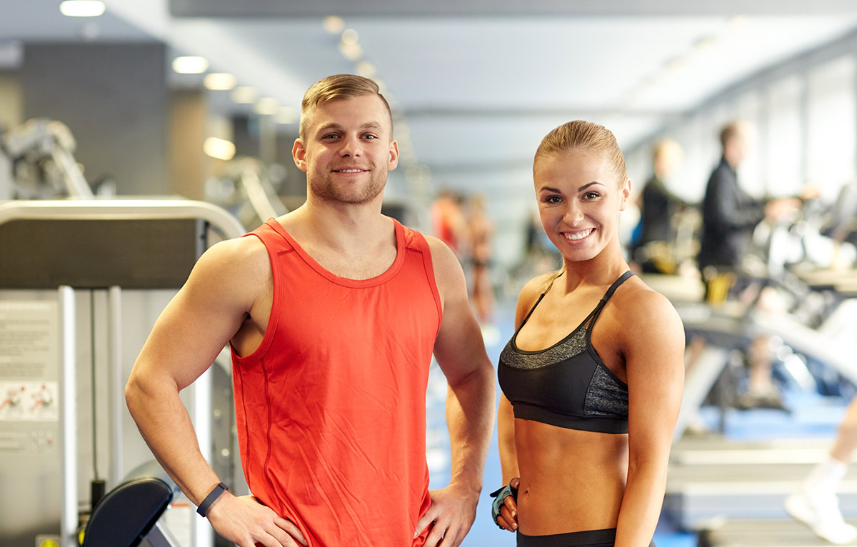 Fitness trainers smile and stand next to each other